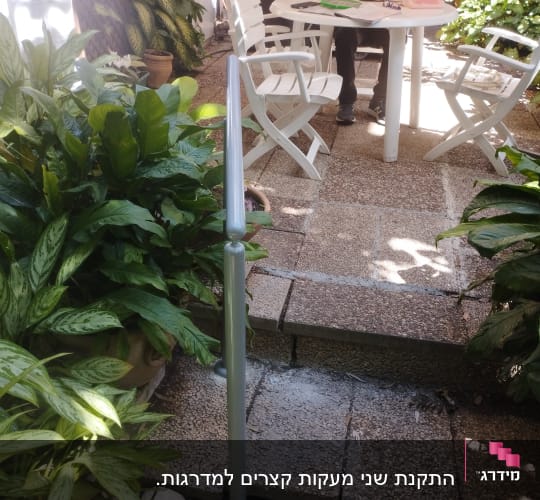 מעקה מתכת מותקן על מדרגות בגינה
